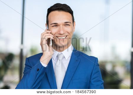 happy businessman talking on cell phone at airport