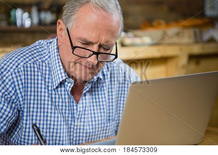 Senior man working on computer in cafÃÂ©