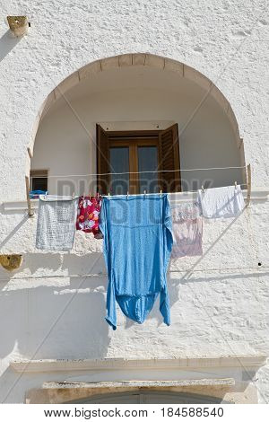 Wooden window with clothes. Locorotondo. Puglia. Italy.