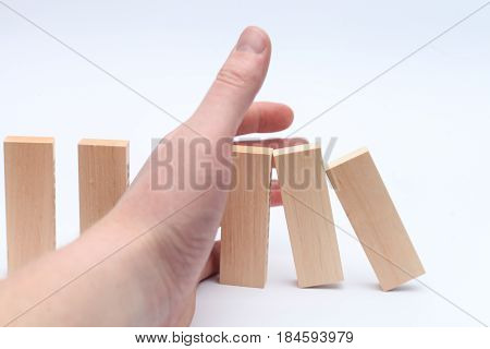 Hand stops the Domino principle. Successful business. Solution. Business concept. On a white background. Horizontally.