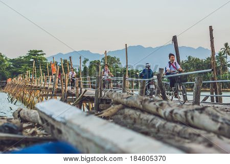 Vietnam Nha Trang - April 10 2017: Old wooden bridgeAnd Vietnamese pioneers