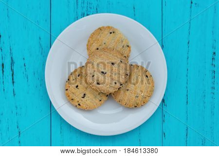 top view biscuit with seasame on dish on a blue wood background