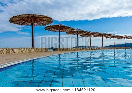 Dalmatian coast Croatia - May 09 2016: Swimming pool with tropical sunshades
