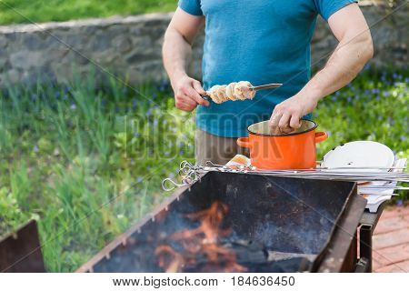Man stringing meat on a skewer. Shashlik - cooking barbecue. Stringing meat on ramrod.