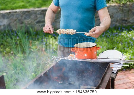 Man stringing meat on a skewer. Shashlik - cooking barbecue. Stringing meat on ramrod.