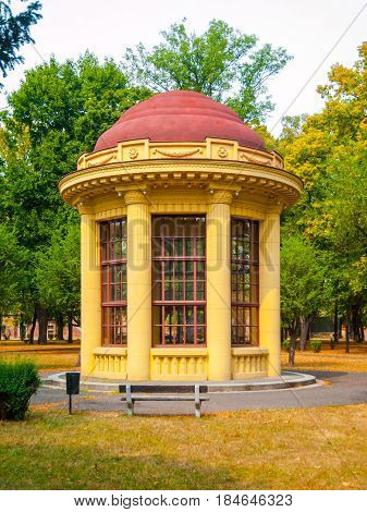 Park gazebo with red roof and yellow facade, Terezin, Czech Republic.