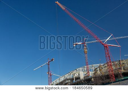 Football stadium construction with cranes and blue sky in Moscow.