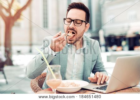Businessman having a salad for lunchhealthy eating.He is working while taking a break.