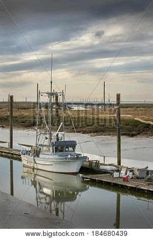 Scotch Pond Low Tide, Steveston. A gillnetter tied to the wharf in Scotch Pond, Steveston, British Columbia.