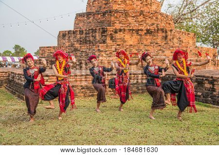 KALASIN THAILAND - FEBRUARY 20 2016: Girl and boy dancers with local dress doing Thai Northeastern traditional dance at Yaku Pagoda to celebrate Buddism event in Kalasin