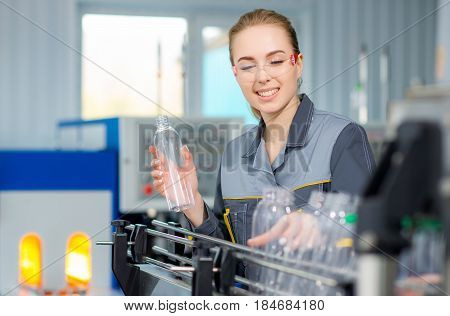 Female worker at a water bottling factory near conveyor