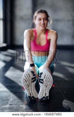 fitness sport training gym and lifestyle concept - smiling teenage girl stretching on mat in the gym