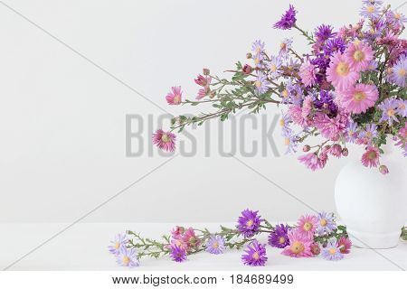 flowers in ceramic vases on white background