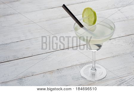 margarita cocktail with lime on white woodenbackground.