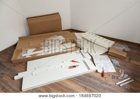 Furniture assembly parts and tools for self assembly furniture on the floor.