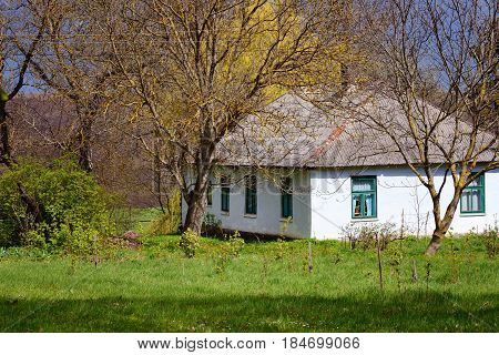Old traditional ukrainian rural cottage in sunlight of spring