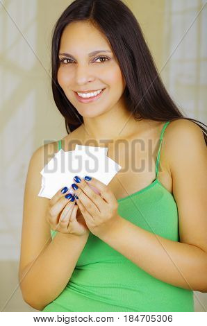Young beautiful woman with a green blouse holding a couple of hygenic towels.