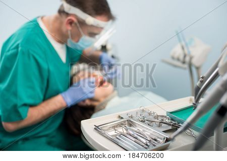 Different Professional Dental Devices, On The Blurred Background Dentist Is Treating Patient In Dent