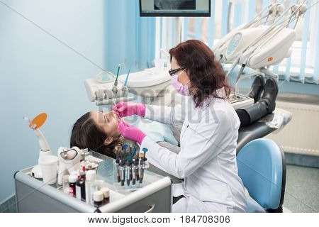 Female Dentist With Dental Tools - Mirror And Probe Checking Up Patient Teeth At Dental Clinic Offic