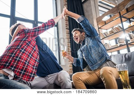 excited young men giving highfive. young people having fun concept