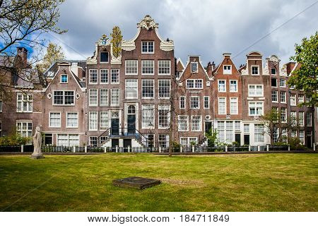 Begijnhof houses and garden in Amsterdam, Netherlands. The Begijnhof is one of the oldest inner courts in the city of Amsterdam