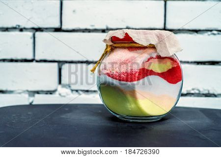 Souvenir glass jar filled with layers of sand of variuos colors