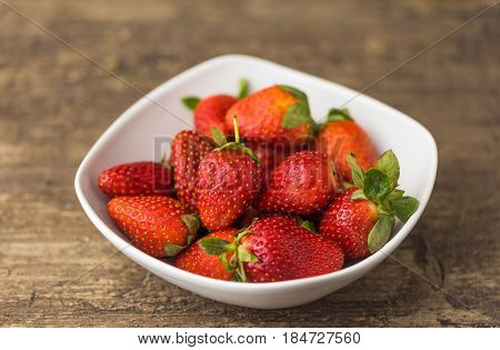 Freshly Handpicked Strawberries in a Bowl on White Wooden Table