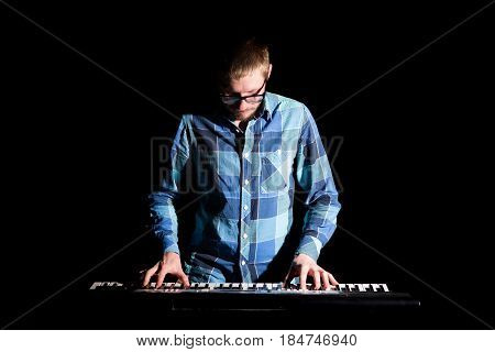 Keyboarder In Plaid Shirt Playing On Dark Background
