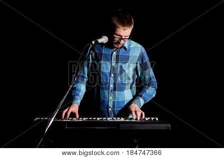 Musician Playing On Keyboard Electric Piano And Singing On Dark. Musician Concept