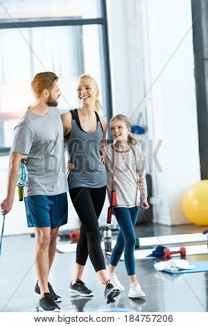 Young Parents And Daughter With Skipping Ropes At Health Club