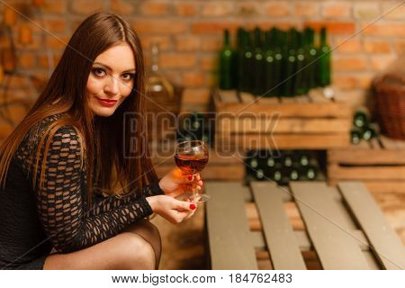 Woman Tasting Wine In Rural Cottage Interior