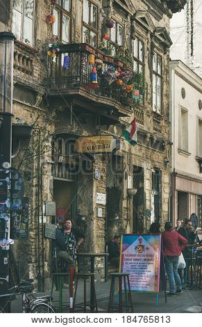 BUDAPEST, HUNGARY - MARCH 26, 2017: Kazinczy Street and facade of the most popular ruin pub of Budapest Szimpla Kert, unknown people around