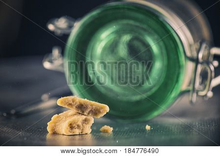 Close up detail of marijuana extraction concentrate aka wax crumble with green glass jar
