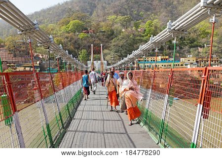 INDIA, LAXMAN JHULA - APRIL 8, 2017: People walking on the suspension bridge in Laxman Jhula on the 8th of april 2017