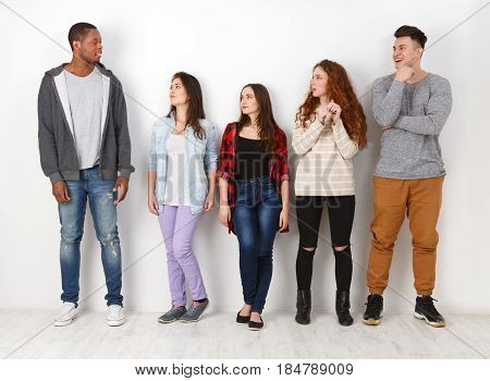 Group of people. Diverse students in casual outfits standing in line on white studio background