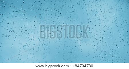 Blue glass with raindrops background texture horizontal top view isolated rain on the window backdrop light blue sky clear water on space blank back mockup nuture wall