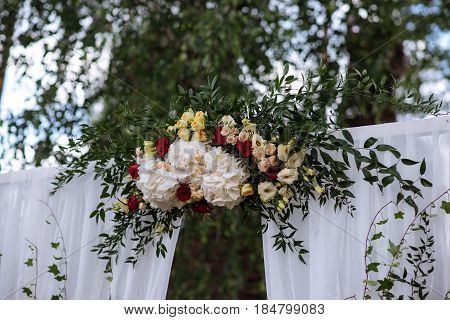 Beautiful Wedding Ceremony Outdoors. Decorated Chairs Stand On The Grass. Wedding Arch Made  Flowers
