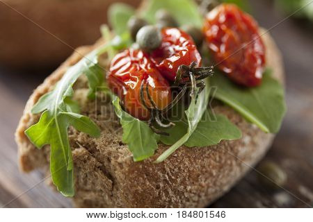 rusk  with rocket, sundried tomatoes and capers