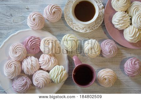 Sweet homemade dessert - marshmallow (zephyr) with cup of tea.Homemade marshmallows on a light background. Russian currant and mango zephyr.