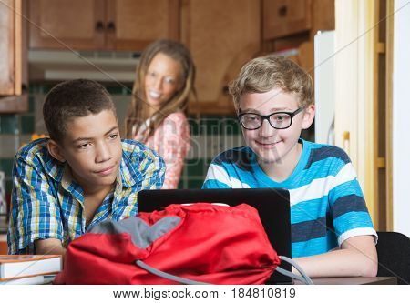 Mother Watching Son And Friend Do Homework