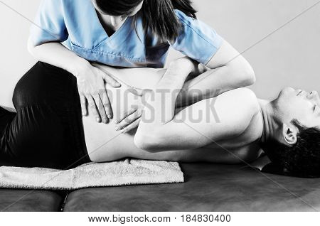 Physiotherapist Doing Manipulation To Man Patient In Silhouette Studio. Osteopathy.