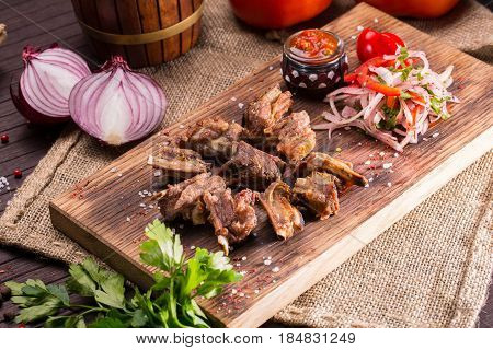 Fried mutton sunflower seeds, are served with sauce ajika and vegetables