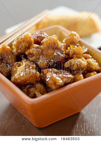 General TSO kylling i en skål med æg roll i baggrunden