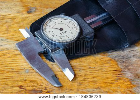 Slide caliper with a round dial in a storage case