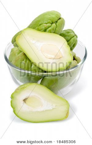 Intere e a fette Chayote verdure fresche in una ciotola di vetro, isolate su sfondo bianco studio.