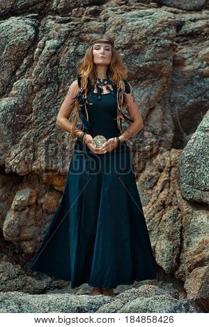 young beautiful woman with tarot cards in her hands with stone background