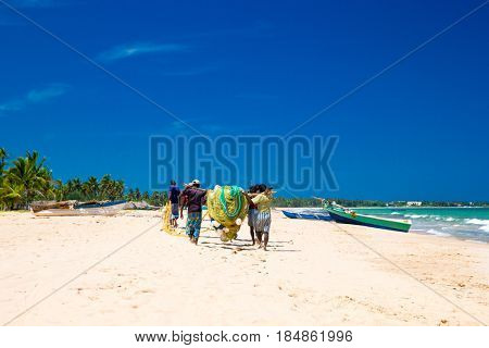 SRI LANKA - Mach 23: Local fishermen pull a fishing net from Indian Ocean on Mach 23, 2017 in Kosgoda, Sri Lanka. Fishing in Sri Lanka is the way they earn their living.
