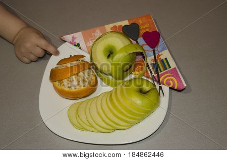the cut fruit on a plate apple orange the child's handle.
