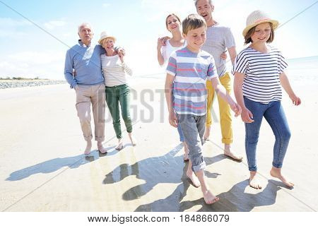 Happy intergenerational family walking on the beach