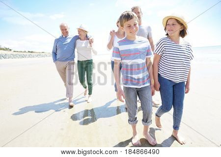 Happy intergenerational family walking on the beach